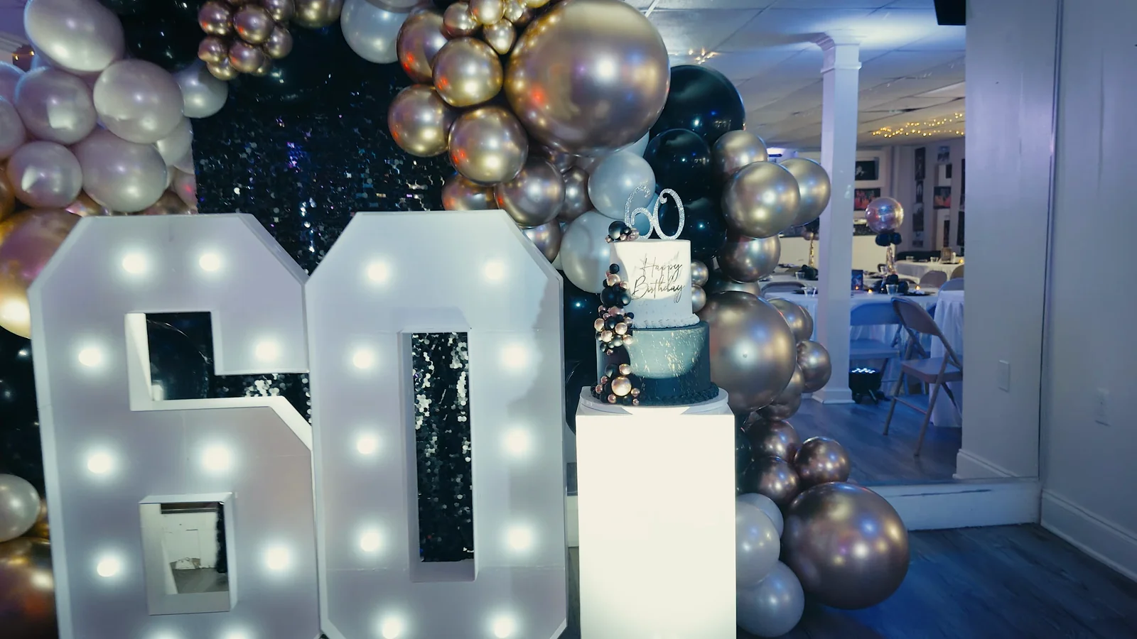 Decoración de cumpleaños con globos, pastel y el número 60