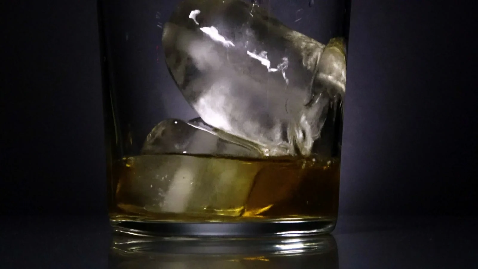 Whiskey servido sobre hielo, entre luz y sombras