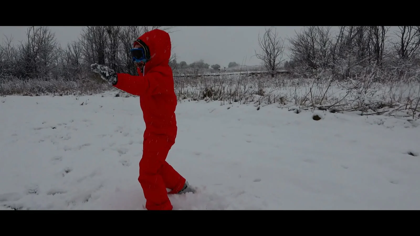 Un niño de rojo camina sobre la nieve